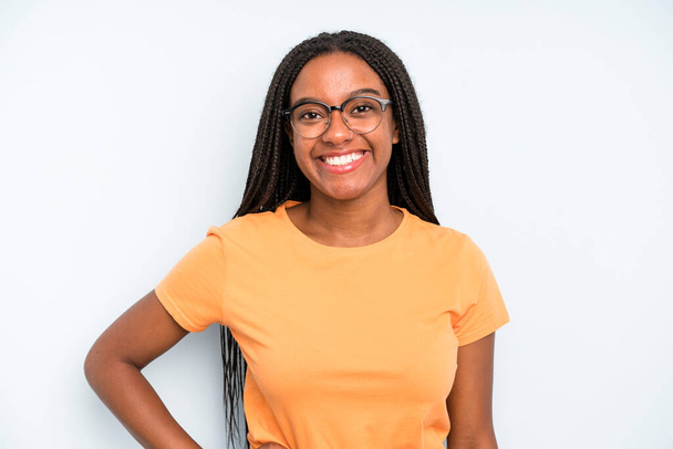 black young adult woman smiling happily with a hand on hip and confident, positive, proud and friendly attitude - Фото, зображення