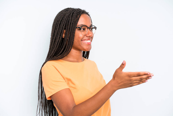 black young adult woman smiling, greeting you and offering a hand shake to close a successful deal, cooperation concept - Foto, Imagen
