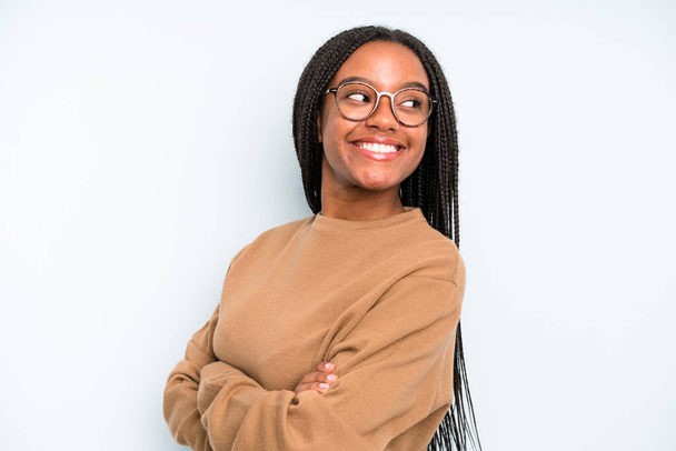 black young adult woman smiling gleefully, feeling happy, satisfied and relaxed, with crossed arms and looking to the side - Fotoğraf, Görsel