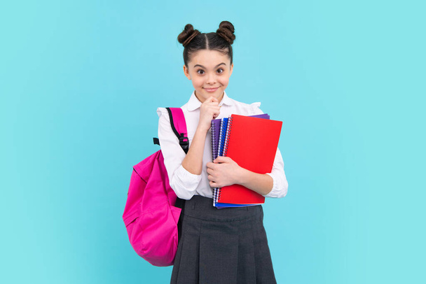 School teenager child girl with book and copybook. Teenager student, isolated blue background. Learning and knowledge. Go study. Education concept. Happy teenager, positive and smiling emotions - Fotó, kép