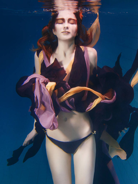 красивая артистичная молодая женщина в платье танцует под водой. Русалочка, харвест, танец, сказочная концепция - Фото, изображение