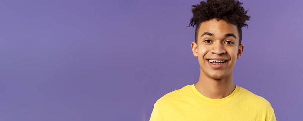 Close-up portrait of cheerful smiling man looking happy, express enthusiastic optimistic emotions, seeing something pleasant and interesting, standing purple background. - Photo, image