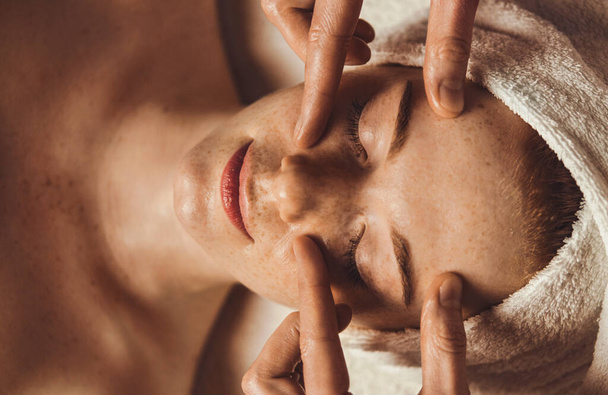 Top view of a Beautiful Caucasian woman receiving eye massage at spa salon. Facial beauty. Beauty woman face skin care. Natural beauty. Health care concept. - Photo, Image
