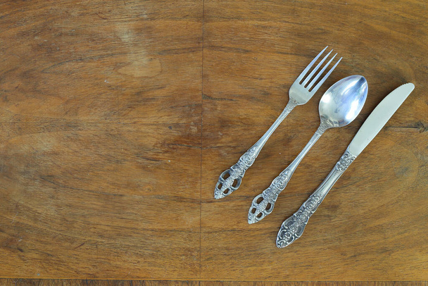 Overhead shot of silverware on wooden table with copy space. - Photo, Image