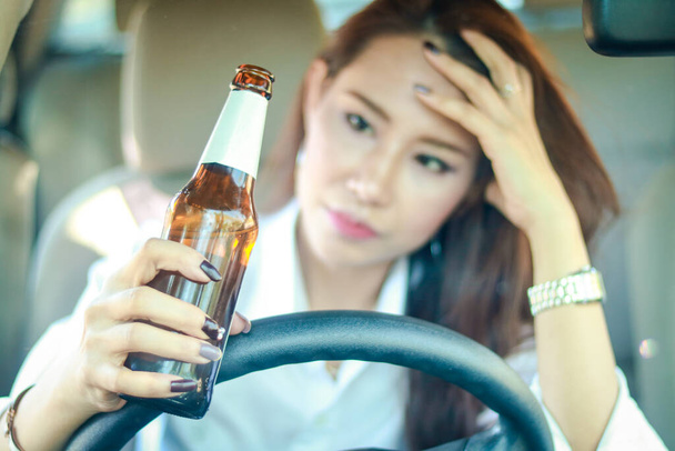 Γυναίκα που πίνει αλκοόλ σε ιδιωτικό αυτοκίνητο Υπάρχει κίνδυνος να οδηγήσει ένα ατύχημα. Έννοια μεταφοράς. - Φωτογραφία, εικόνα
