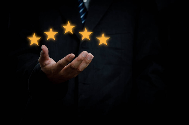 Business man hand customer or client holding the stars to complete five stars with copy space.business satisfaction feedback marketing concept. - Foto, imagen