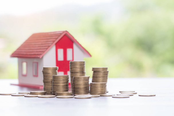House model and money coins stacks with blur nature background. Savings plans for home, loan, investment, mortgage, finance and banking about house concept. - Fotografie, Obrázek