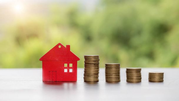 House model and money coins stacks with blur nature background. Savings plans for home, loan, investment, mortgage, finance and banking about house concept. - Photo, Image