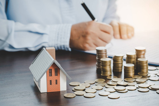 House model with stack coins, business hand is planning savings money of coins for buy home. concept for property ladder, mortgage with real estate investment and saving or investment for a house - Photo, image