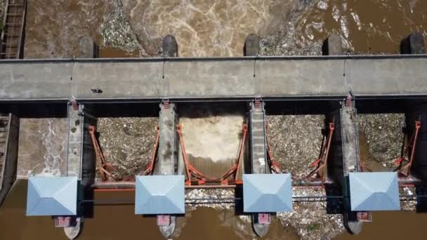 Aerial view of water released from the drainage channel of the concrete dam is a way of overflowing water in the rainy season. Top view of turbid brown forest water flows from a dam in rural northern Thailand. - Metraje, vídeo