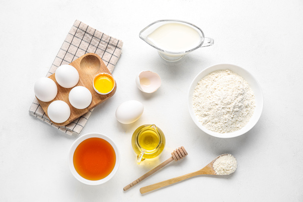 Composition with different ingredients for baking on light background - Fotó, kép