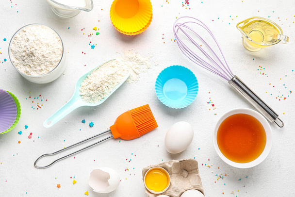 Composition with ingredients for baking pastry and utensils on light background - Photo, image