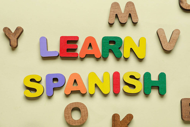 Text LEARN SPANISH with letters on beige background - Foto, Imagem