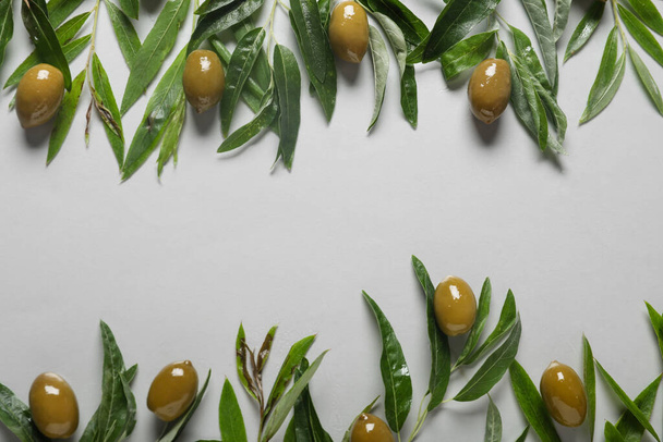Composition with green olives and leaves on light background - Foto, immagini