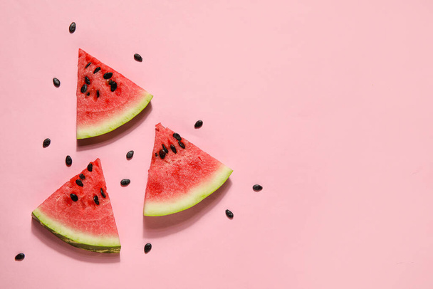 Slices of tasty watermelon with seeds on pink background - Fotó, kép