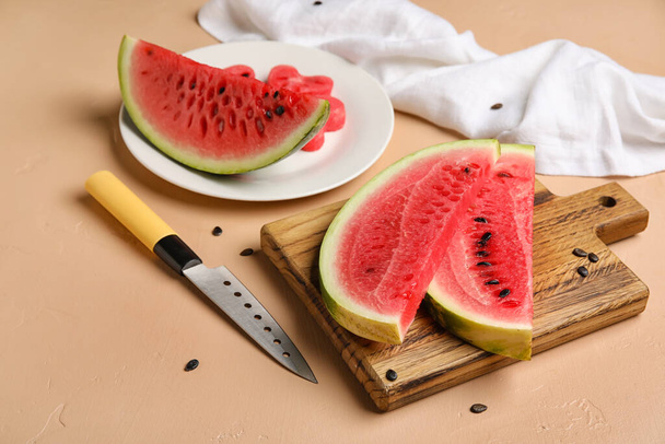 Plate, board with slices of watermelon and knife on beige background - Foto, Imagem