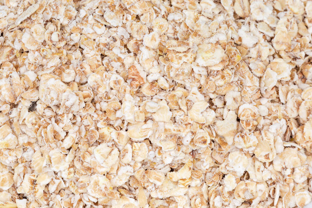 Evenly sprinkled raw thin-rolled oats close-up, background - Foto, Imagem