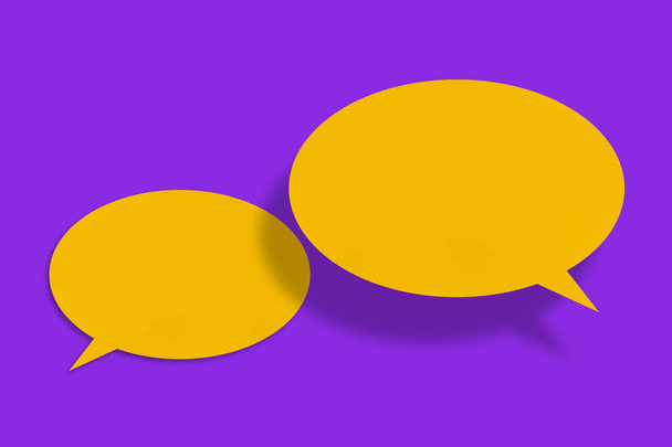 Balon mowy w kształcie żółtego papieru na fioletowym tle.design - Zdjęcie, obraz
