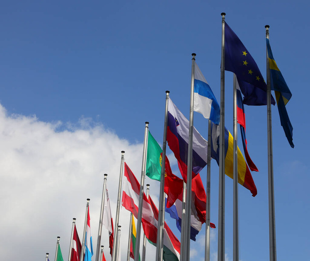 flag of Europe and other flags on the background with blue sky and clouds - Fotografie, Obrázek