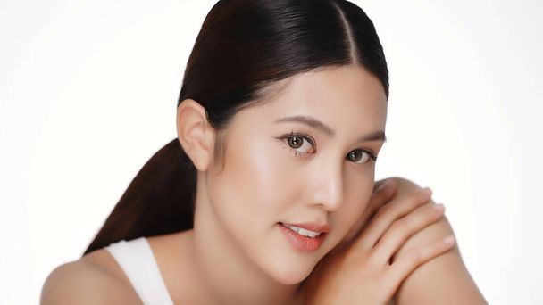 Beauty young Asian woman face looking at camera, isolated on white background. Skin care treatment or cosmetic ads concept. Beautiful female model with perfect fresh and clean skin. - Photo, Image