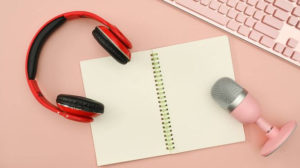 Above view of podcast recording equipment with headphone, microphone and notepad on pink background. - Valokuva, kuva
