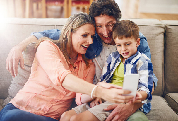 Making treasured memories together. a family taking a selfie together at home - 写真・画像