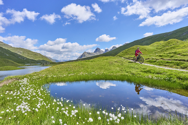 nice active senior woman riding her electric mountain bike in the silvretta mountain range near Gaschurn, Tyrol, Austria - Zdjęcie, obraz