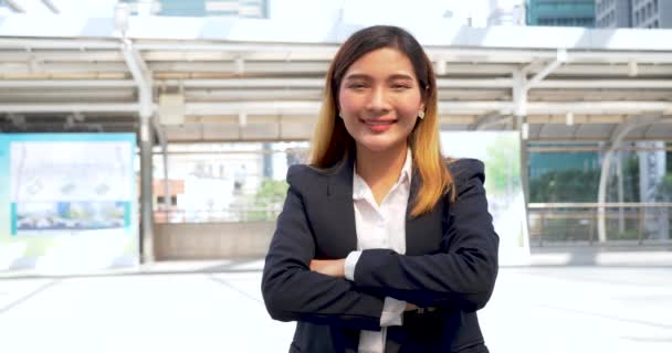 Portrait Business woman arms crossed smiling look at camera in modern city background. Happy Business people positive achievement standing and smile. Happy leader executive young asian women leader - Filmati, video