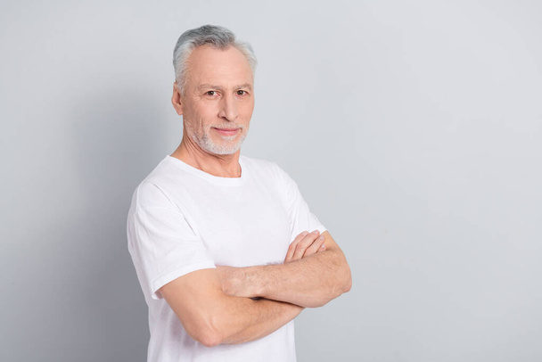 Photo of nice aged man crossed arms wear white t-shirt isolated on grey color background. - Fotografie, Obrázek