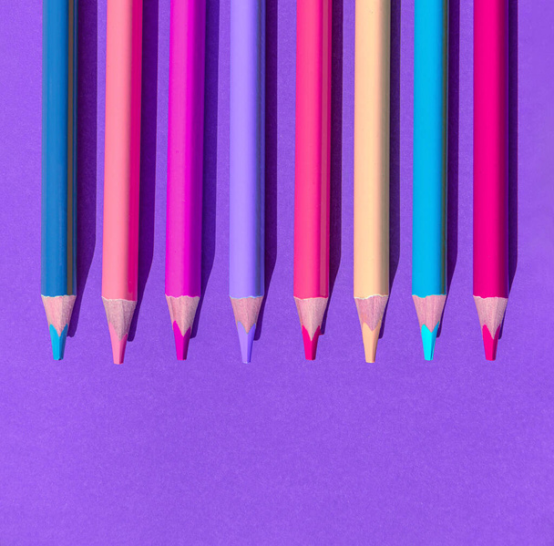 Набор красочных деревянных карандашей на фиолетовом фоне. Минимальный стиль. Вид сверху. Плоский лежал. Снова в школу. - Фото, изображение