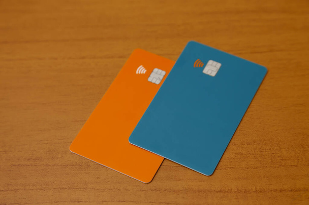 πράσινες και πορτοκαλί πιστωτικές ή χρεωστικές ανέπαφες κάρτες με επαφή λιγότερο σημάδι. Ψηφιακό σύστημα πληρωμών. - Φωτογραφία, εικόνα