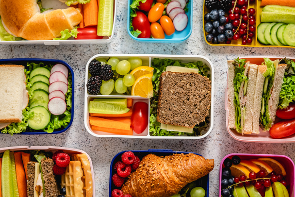 Shot of school lunchboxes with various healthy nutritious meals on stone background, Top view, flat lay - Foto, imagen