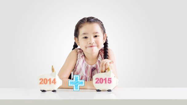 Маленька дівчинка кладе гроші на скарбничку з новим роком 2015 року. Економія концепції з 2014 по 2015 рік малюнок
 - Фото, зображення