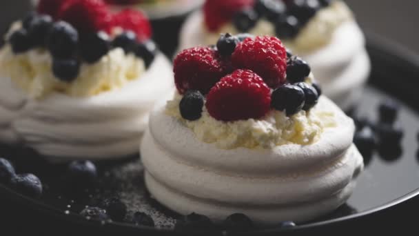 Delicious mini pavlova meringue desserts served with frozen frosty berries and mascarpone whipped cheese. Flat lay - 映像、動画
