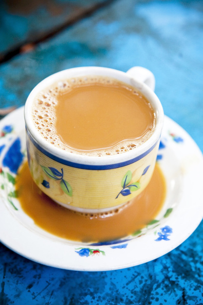 Бірманська молока чай на синій дерев'яний стіл - Фото, зображення