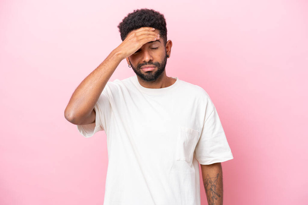 Young Brazilian man isolated on pink background with headache - Фото, изображение