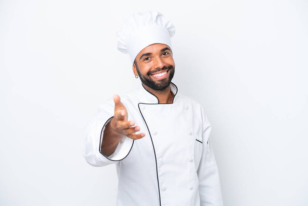 młody brazylijski kucharz człowiek odizolowany na białym tle uścisk dłoni za zamknięcie dobry interes - Zdjęcie, obraz