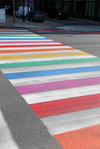 large pedestrian crossing with lines of many rainbow colors on the street - Foto, Imagen
