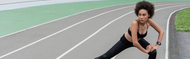 σπορ αφρικανικής Αμερικής γυναίκα με σγουρά μαλλιά κάνει πλευρική lunge άσκηση, πανό - Φωτογραφία, εικόνα