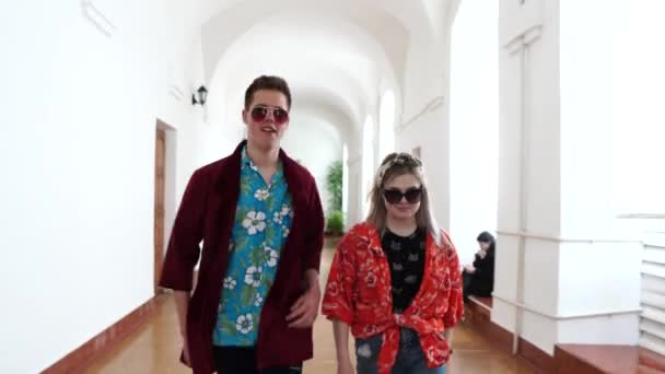 young students in sunglasses walk like models in the school hall - Кадры, видео