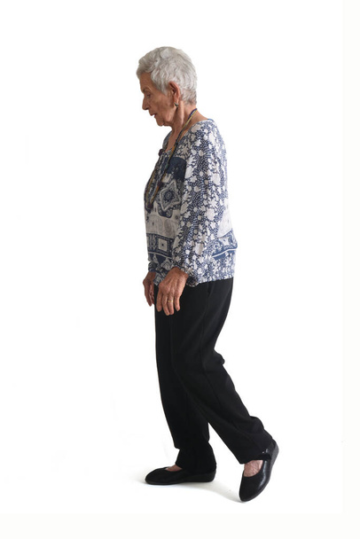 full portrait of a senior woman side view, walking on white background - Foto, afbeelding