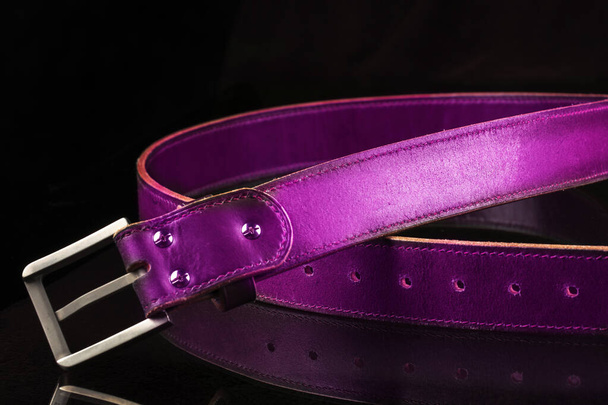 Leather pink belt on a black background. - Fotografie, Obrázek