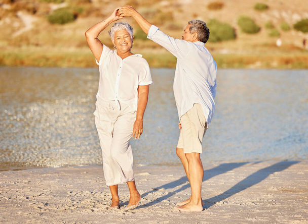 Sand, beach and dancing happy senior couple on summer retirement holiday travel or spring vacation by water. Love fun and elderly playful dancer people on outdoor sea, ocean and sunshine nature trip. - Foto, imagen