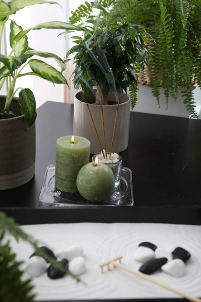Candles and incense sticks near miniature zen garden on black table - Photo, image