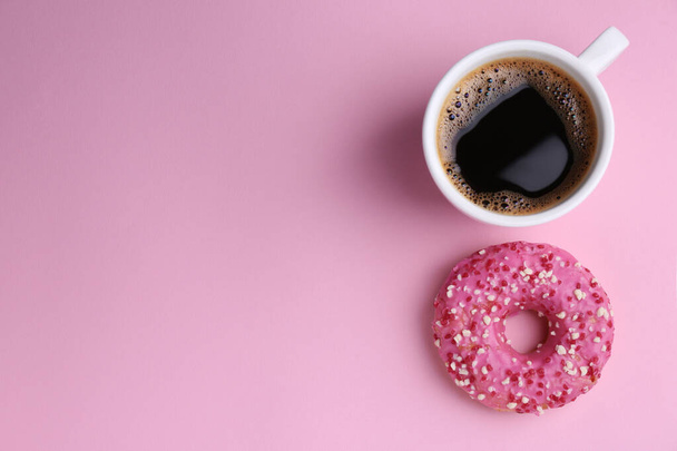Tasty donut and cup of coffee on pink background, flat lay. Space for text - Foto, immagini