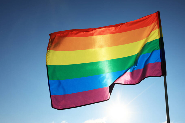 Bright LGBT flag fluttering against blue sky - Foto, Bild