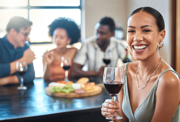 Social, happy and wine of a woman with a glass of alcohol at a dinner table with friends in a restaurant. Young female with smile in luxury fun dining with people at a celebration or event indoors - Foto, Imagem