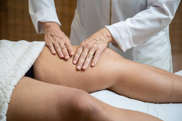 Професійний терапевтичний масаж на нозі пацієнта, який лежить на носі
. - Фото, зображення