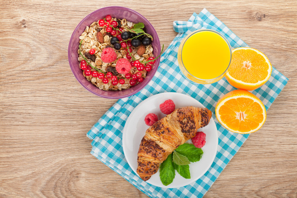 Healthy breakfast with muesli, berries, orange juice and croissa - Photo, Image