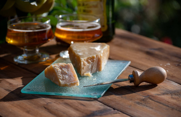 Cheese pairing with drinks,  parmigiano reggiano or parmesan cheese and French apple cider served outdoor in garden - Foto, Imagem